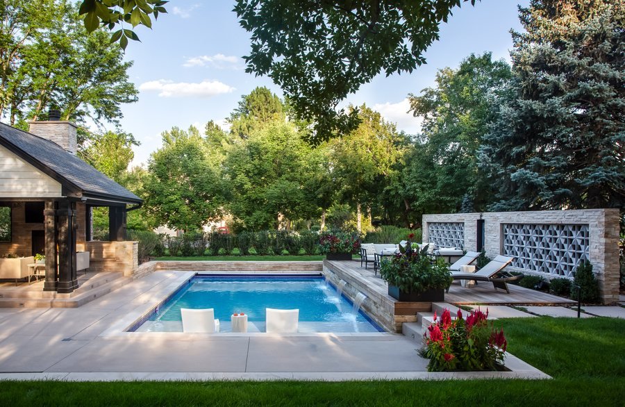 Rectangular pool with in-water loungers, waterfall spouts and a breeze-block privacy wall at the Greenwood Village whole-home remodel.