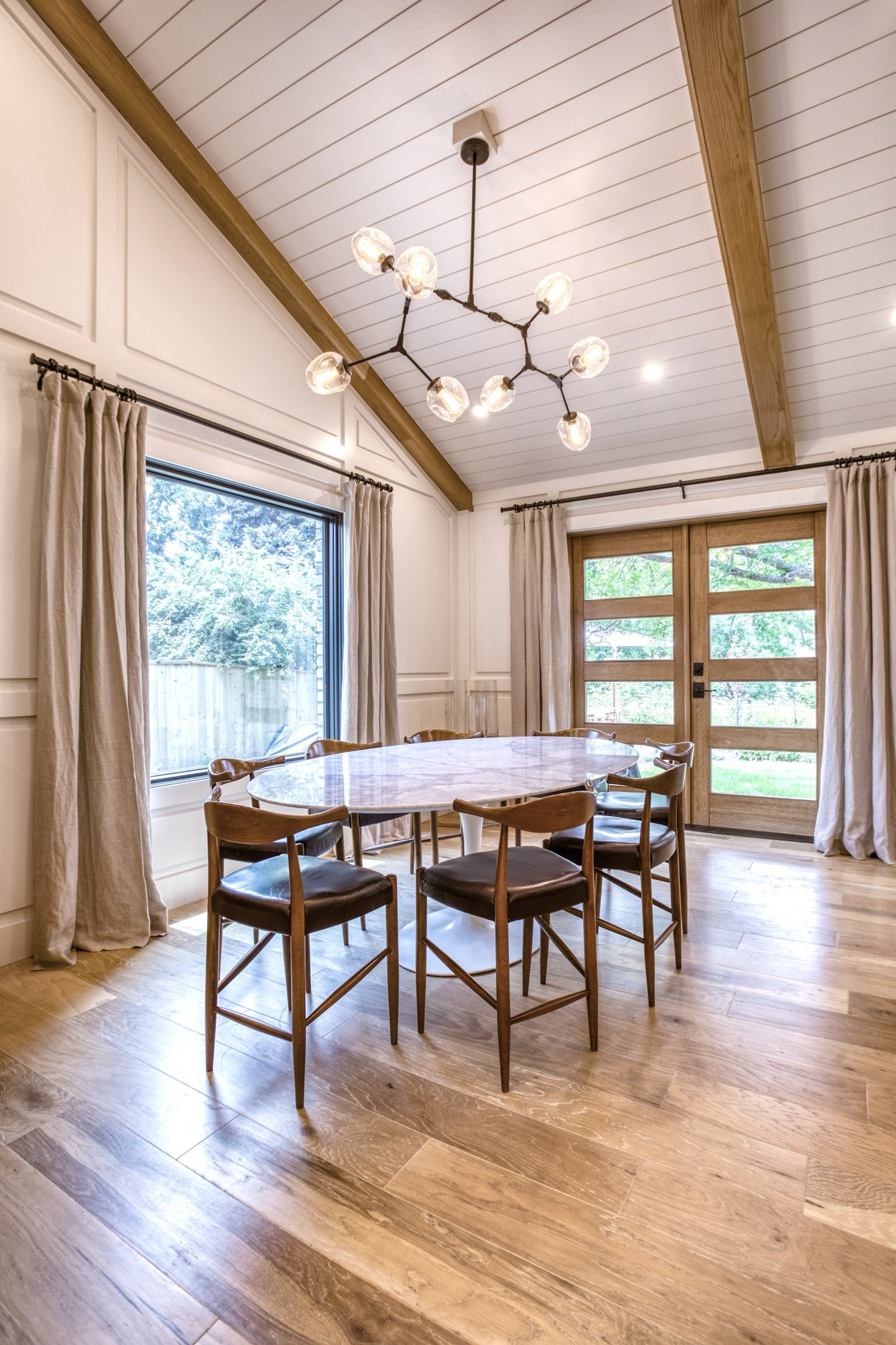 Breakfast nook with round table and mid-century chairs by the window, Fulton Street whole house renovation in Greenwood Village