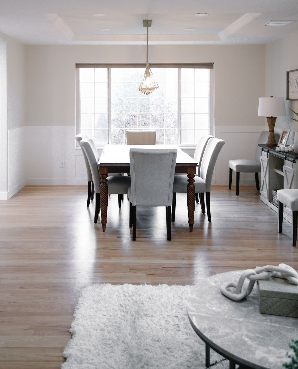 Formal dining room with white table and soft flokati rug, Stonegate main floor renovation in Parker, Colorado