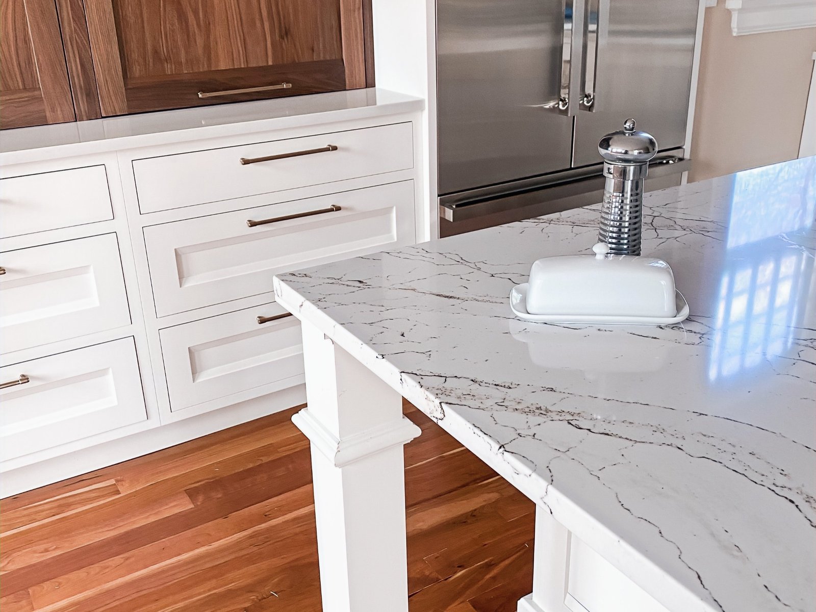 Island with marble-look quartz and warm walnut base, historic Colorado Springs kitchen remodel