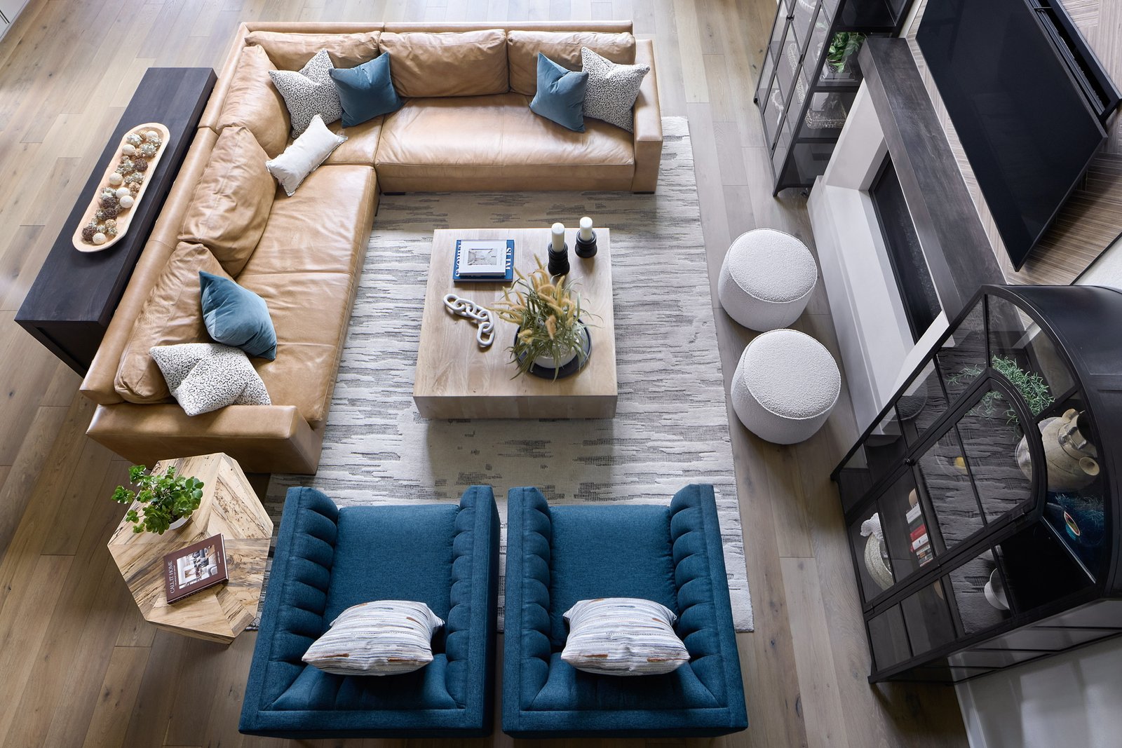 Overhead view of The Canyons living room with tan leather sectional, blue lounge chairs, and layered rug