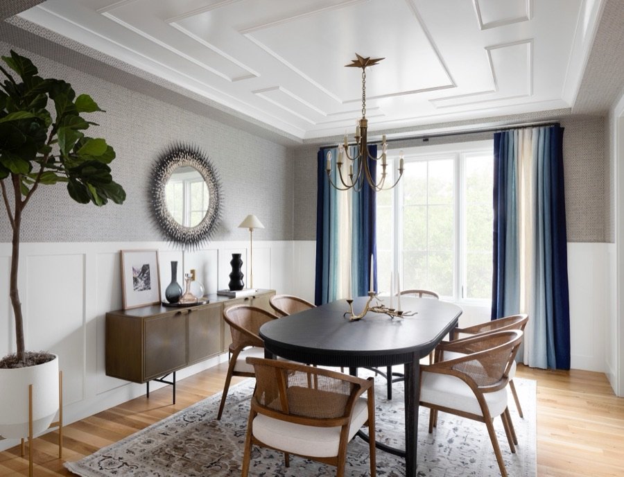 Channel-tufted navy banquette dining nook beneath white oak beams and a brass lantern pendant, whole home renovation by E+E
