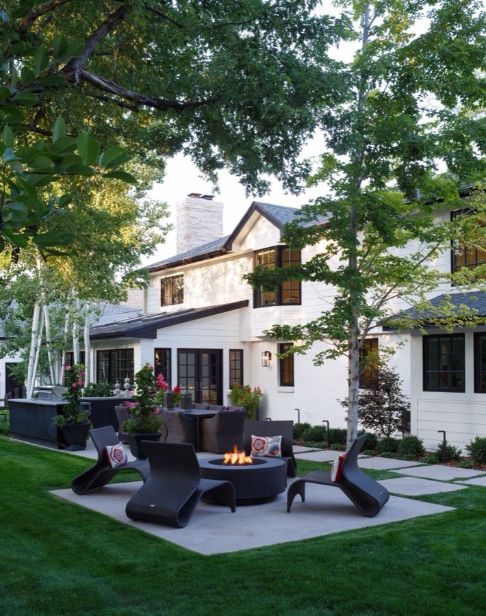 White modern farmhouse exterior with landscaped patio and fire pit seating, from E+E's Greenwood Village whole home renovation