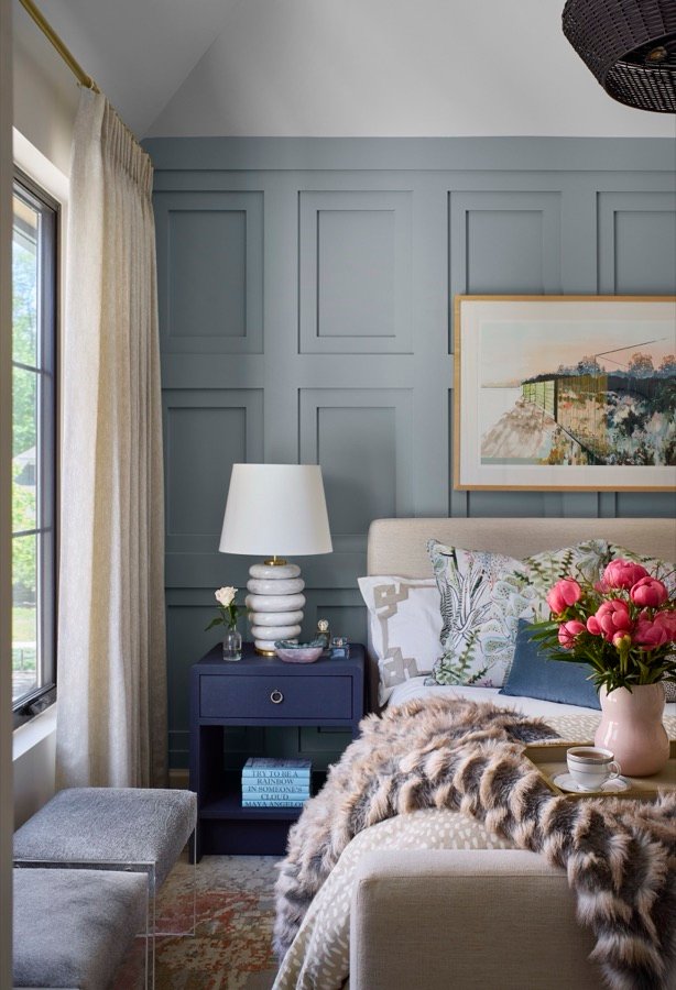 Soft blue bedroom refreshed with layered bedding, art, and warm lighting